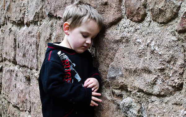 boy leaning against wall